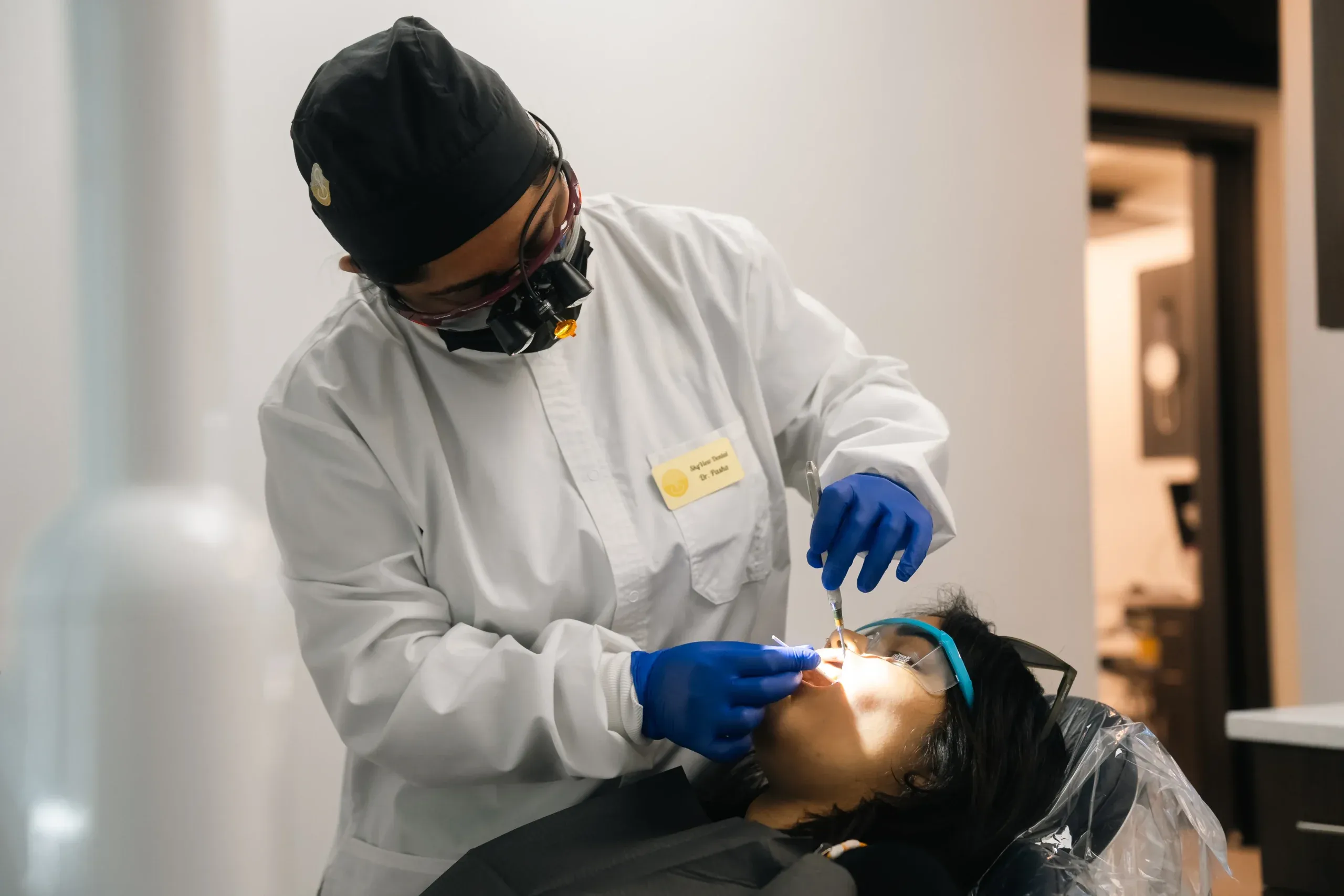Dr. Pasha examining a patient in a Skyview Dental treatment room