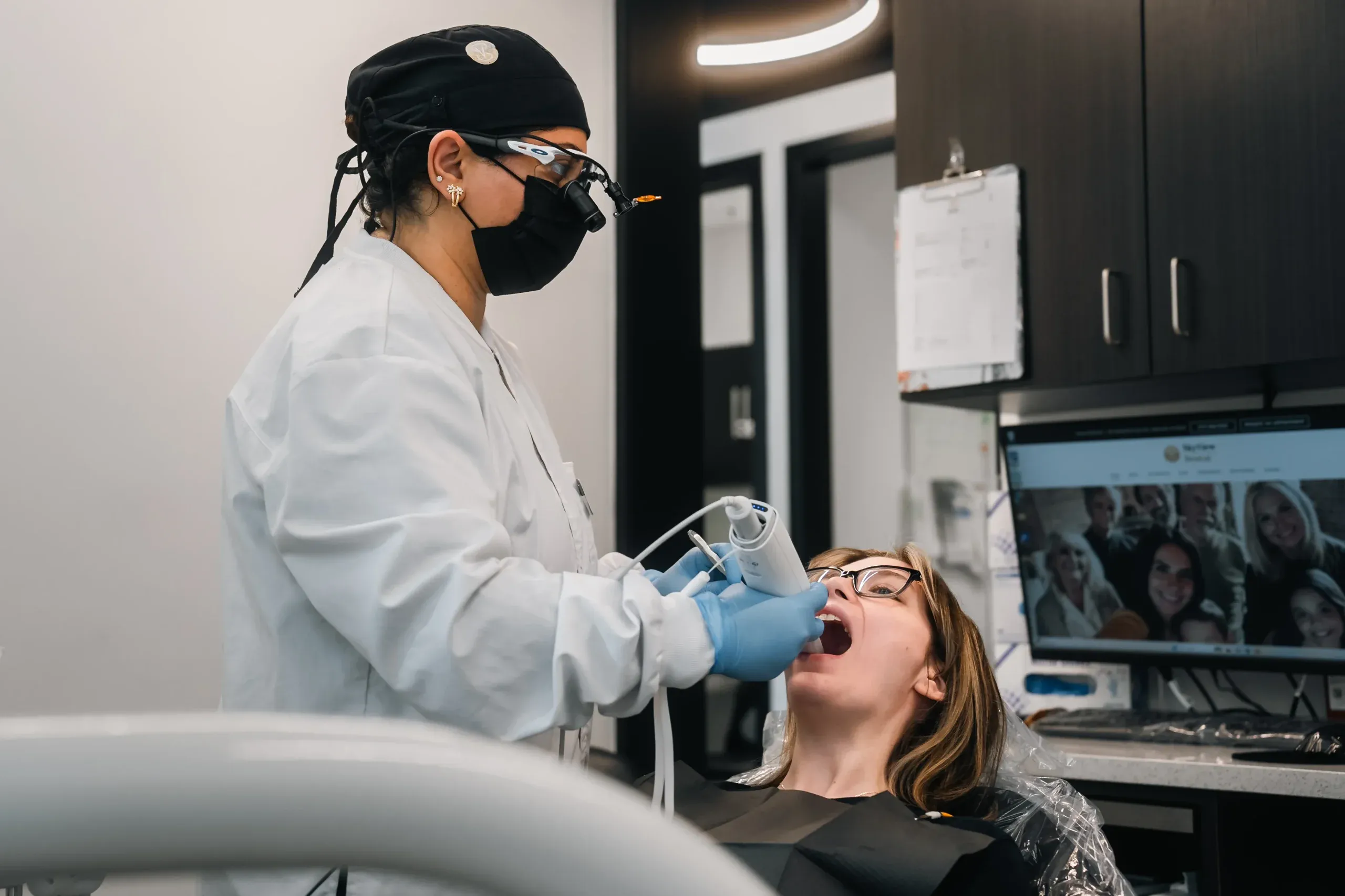Dr. Pasha scanning a patient’s teeth with an intraoral scanner